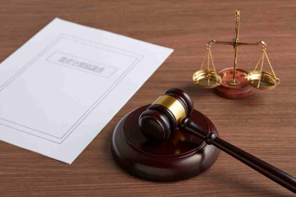 Gavel, scales, and a legal document on a wooden table.